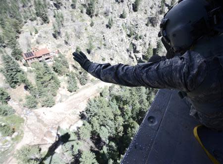 Staff Sergeant Jose Pantoja, with the 2-4 GSAB 4th Infantry Division based in Ft. Carson, waves to people in Left Hand Canyon after they indicated their condition and that they didn't need help from a Blackhawk helicopter near Jamestown, Colorado September 17, 2013. REUTERS/Mark Leffingwell