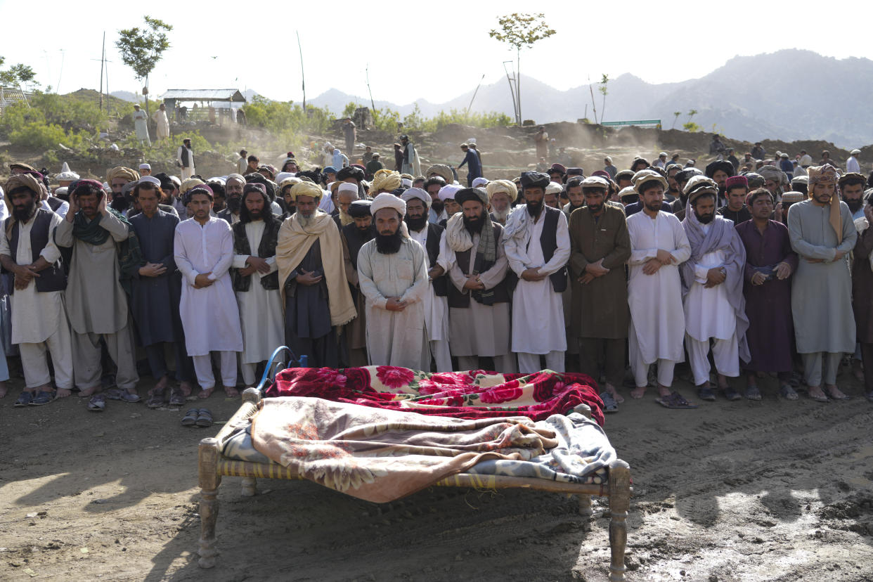 Afghans pray for relatives killed in an earthquake to a burial site l in Gayan village, in Paktika province, Afghanistan, Thursday, June 23, 2022. A powerful earthquake struck a rugged, mountainous region of eastern Afghanistan early Wednesday, flattening stone and mud-brick homes in the country's deadliest quake in two decades, the state-run news agency reported. (AP Photo/Ebrahim Nooroozi)