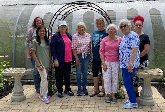 Members of Alliance Garden Club stand with an arbor in Beech Creek Botanical Garden and Nature Preserve's Butterfly House. The group purchased the arbor, which was placed at Beech Creek in memory of lifelong club member Maralee Gruey, who died Feb. 22, 2022, at age 101.