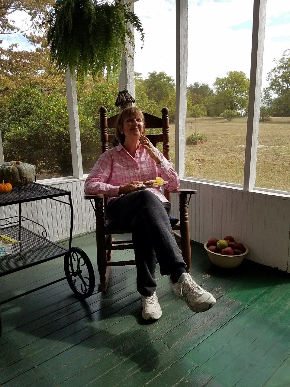 Carole Currie, a retired ACT reporter and editor, sitting on the porch at her Georgia farm.