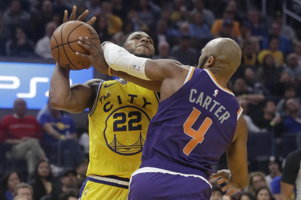 Golden State Warriors forward Glenn Robinson III (22) is fouled by Phoenix Suns guard Jevon Carter (4) during the first half of an NBA basketball game in San Francisco, Friday, Dec. 27, 2019. (AP Photo/Jeff Chiu)