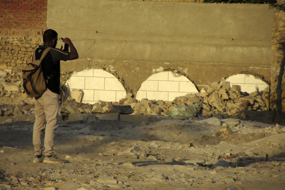 A man films his relatives recently demolished graves in Cairo's historic City of the Dead, Egypt, Sept. 1, 2023. Authorities have already razed hundreds of tombs and mausoleums as they carry out plans to build a network of multilane highways through the City of the Dead, a vast cemetery in the Egyptian capital that has been in use for more than a millennium. (AP Photo/Amr Nabil)