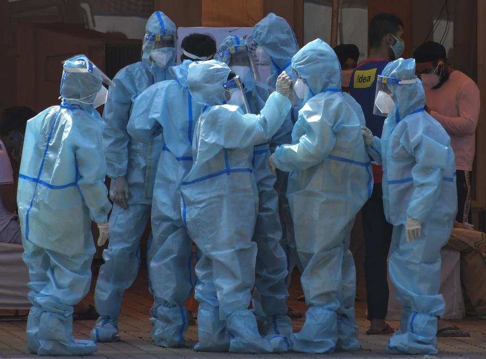 FILE - In this May 10, 2021, file photo, health workers and volunteers in personal protective suits wait to receive patients outside a COVID-19 hospital that was set up at a Sikh Gurdwara in New Delhi, India. The capital of New Delhi is seeing some improvement in the fight against the coronavirus, but experts say the crisis is far from over in the country of nearly 1.4 billion people. Hospitals are still overwhelmed and officials are struggling with short supplies of oxygen and beds. (AP Photo/Ishant Chauhan, File )