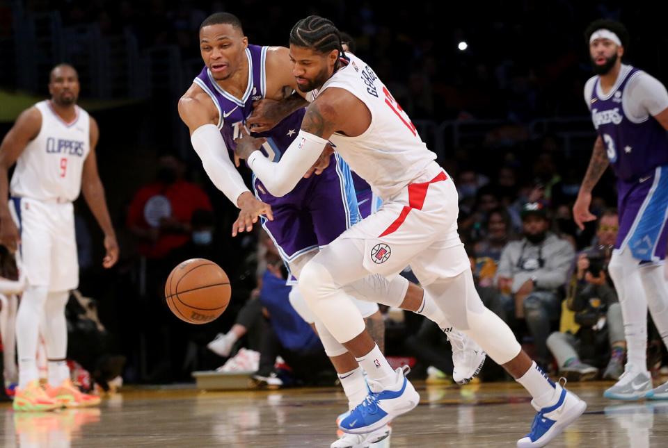 Lakers guard Russell Westrook fights for control of the ball with Clippers forward Paul George.