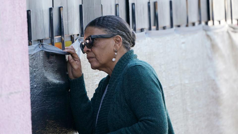 Tanya Britton, a former president of Pro-Life Mississippi, peers through a barrier around Mississippi's only abortion clinic on Nov. 30, 2021, in Jackson, Miss.