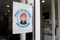 A sign asking customers to wear masks is seen at a shop in Vincennes