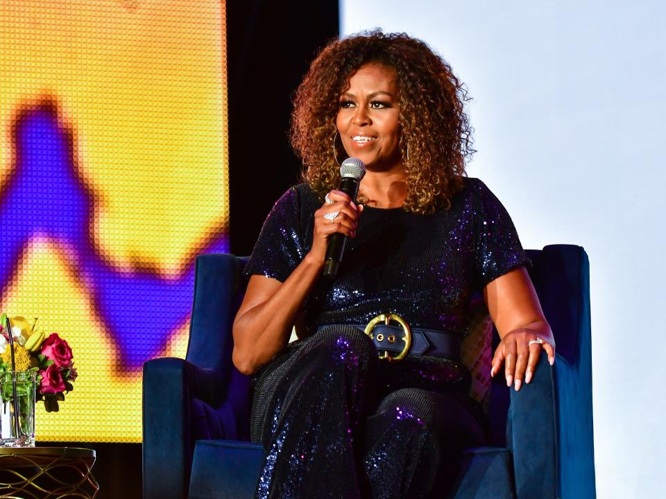 michelle obama speaks into a microphone