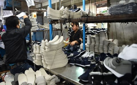 Employees working at a factory of Nepali shoe brand Goldstar in Kathmandu - Credit: AFP