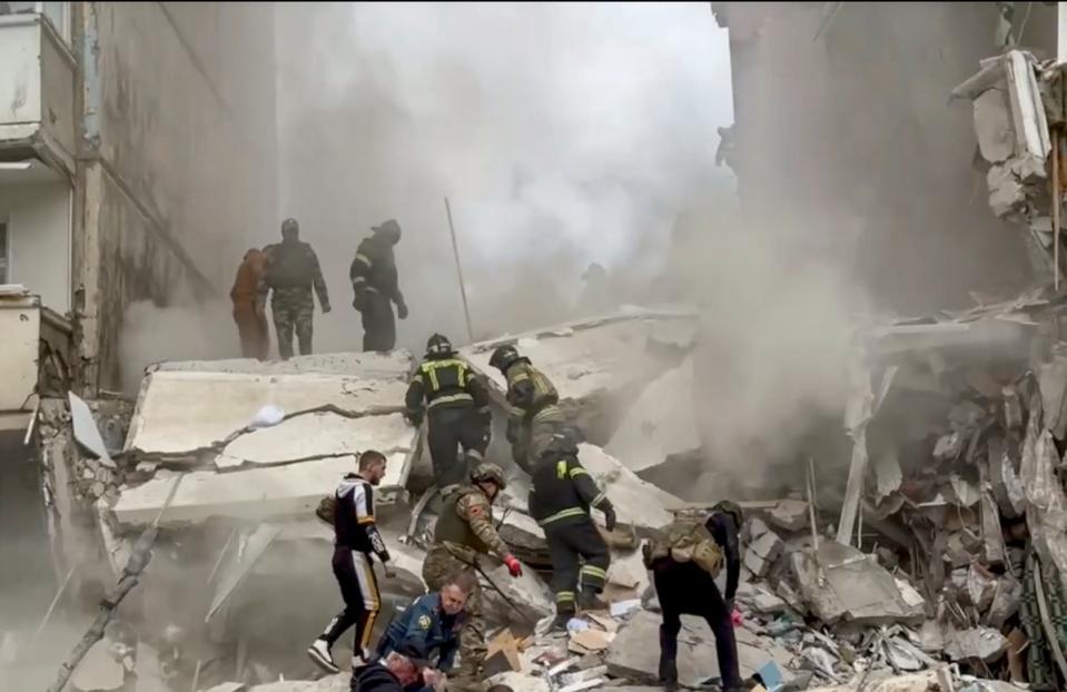 Russian rescuers search for survivors in the rubble after the roof of a destroyed apartment block in Belgorod collapsed onto emergency workers (EPA)