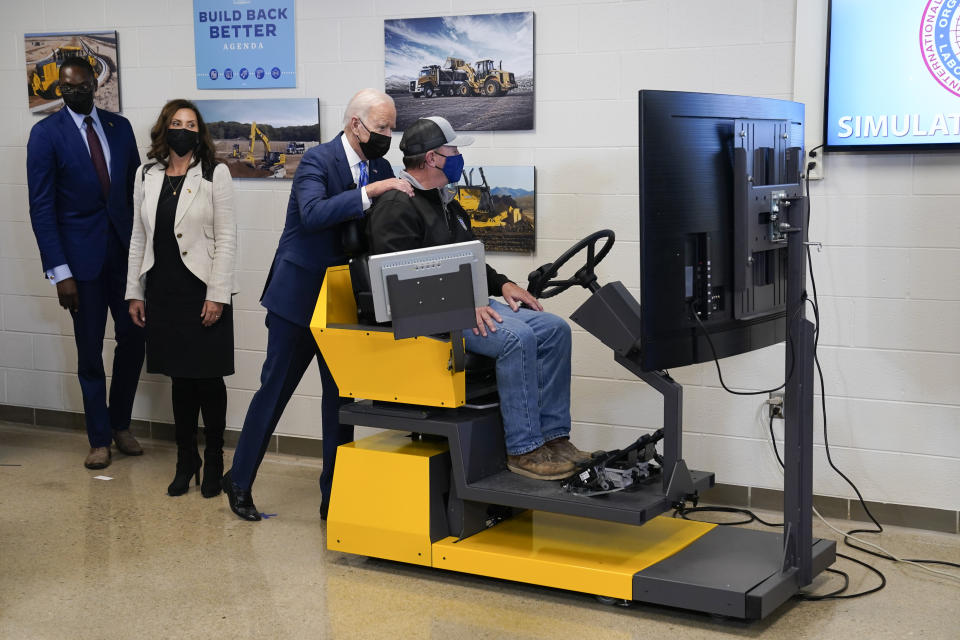 President Joe Biden tours the International Union Of Operating Engineers Local 324 training facility, Tuesday, Oct. 5, 2021, in Howell, Mich. Michigan Lt. Gov. Garlin Gilchrist, left, and Michigan Gov. Gretchen Whitmer second from left, look on. (AP Photo/Evan Vucci)