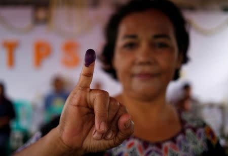 An Indonesian woman shows her ink-stained finger after casting her vote during regional elections in Tangerang, west of Jakarta, Indonesia June 27, 2018. REUTERS/Willy Kurniawan