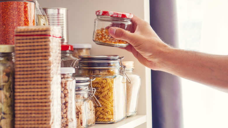 Reaching into cluttered cabinet