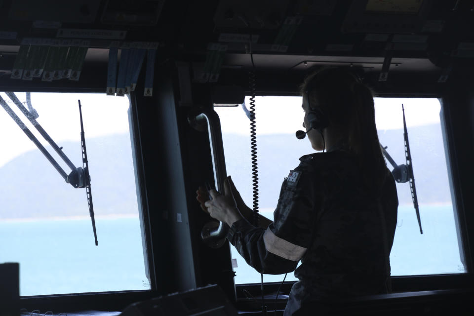 In this photo provided by the Australian Defence Force, a navy sailor from HMAS Brisbane observes from the bridge during search and rescue operations in the vicinity of Lindeman Island, Australia on Saturday, July 29, 2023, as part of a multi-national and multi-agency search and rescue effort following an Australian Army MRH-90 Taipan helicopter ditching in waters near the island. The helicopter hit the water off Australia's northeast coast with a "catastrophic impact" on Friday and there was no chance that that any of the four air crew would be found alive, officials said on Monday, July 31, 2023. (LSEW Hannah LinsleyADF via AP)