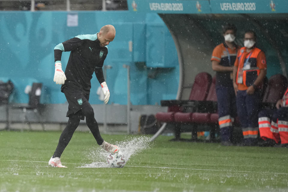 Austria's goalkeeper Alexander Schlager kicks a ball during a heavy rainfall before a training session at the National Arena stadium in Bucharest, Romania, Saturday, June 12, 2021, the day before his team's first match against North Macedonia. (AP Photo/Vadim Ghirda)