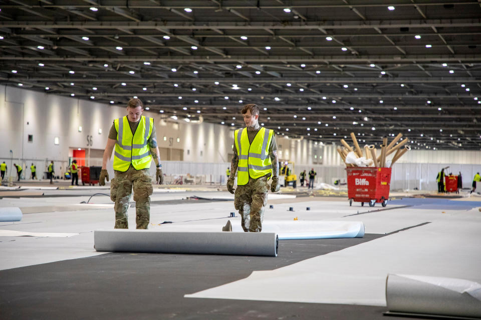 Soldiers from 1 Royal Anglian Regiment roll out carpet.