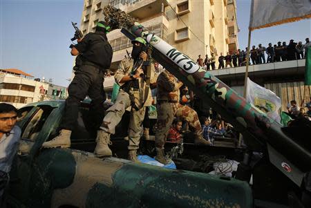 Palestinian Hamas militants stand next to M-75 home made rocket as they take part in a military parade marking the first anniversary of the eight-day conflict with Israel, in Gaza City November 14, 2013. REUTERS/Suhaib Salem