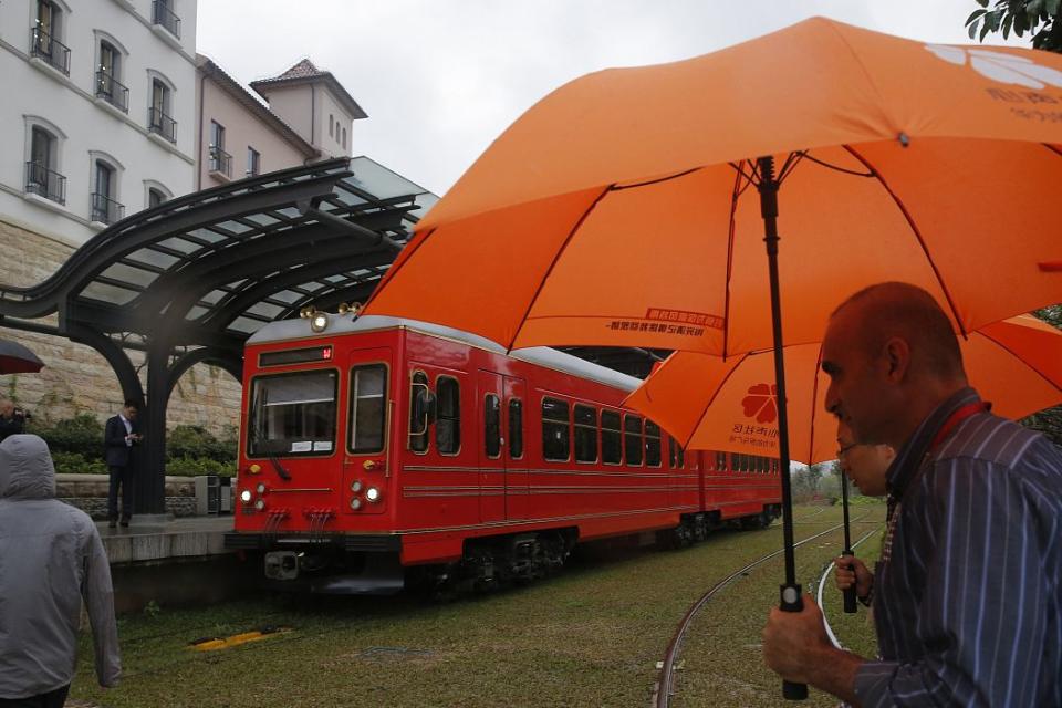 Staff members walk near a train in the Huawei's Ox Horn campus in Songshan Lake in Dongguan, China's Guangdong province