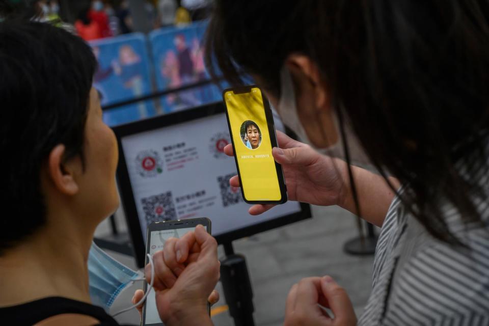 2020年5月3日，中國首都北京，一名商場職員為一位到訪的女人生成健康碼進入商場。