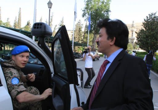 Niraj Singh (C), spokesman for a UN monitoring team in Syria, speaks to a member a UN advance party in Damascus, April 26. UN leader Ban Ki-moon said the Syrian government is "in contravention" of an agreed peace plan by keeping troops and heavy weapons in cities