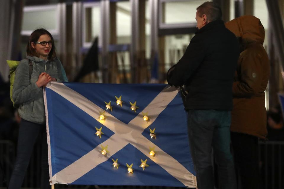 Anti-Brexit protesters gather outside the Scottish parliament in Edinburgh, Friday, Jan. 31, 2020. Britain officially leaves the European Union on Friday after a debilitating political period that has bitterly divided the nation since the 2016 Brexit referendum. (AP Photo/Scott Heppell)