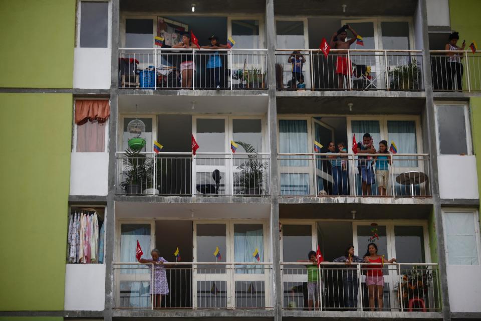Residents watch from their balconies, employees of Petroleos de Venezuela, PDVSA, march past in a pro-government demonstration in Caracas, Venezuela, Tuesday, Feb. 18, 2014. The Venezuelan government accuses the Obama administration of siding with student protesters it has blamed for violence that led to three deaths last week. Maduro claims the U.S. is trying to stir up unrest to regain dominance of South America's largest oil producer.(AP Photo/Alejandro Cegarra)