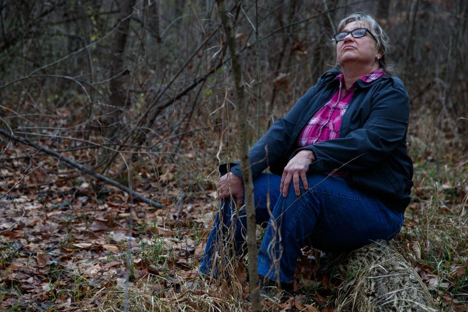 Rae Schnapp, conservation director at Indiana Forest Alliance (IFA), takes a seat on a fallen tree Wednesday, Dec. 15, 2021, in a plot of forest for sale near 30th & Arlington Road in Indianapolis.