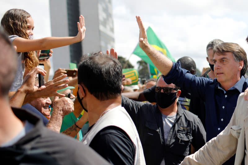 Brazil's President Jair Bolsonaro greets supporters during a protest in his favor in front of the Planalto Palace, amid the coronavirus disease (COVID-19) outbreak, in Brasilia