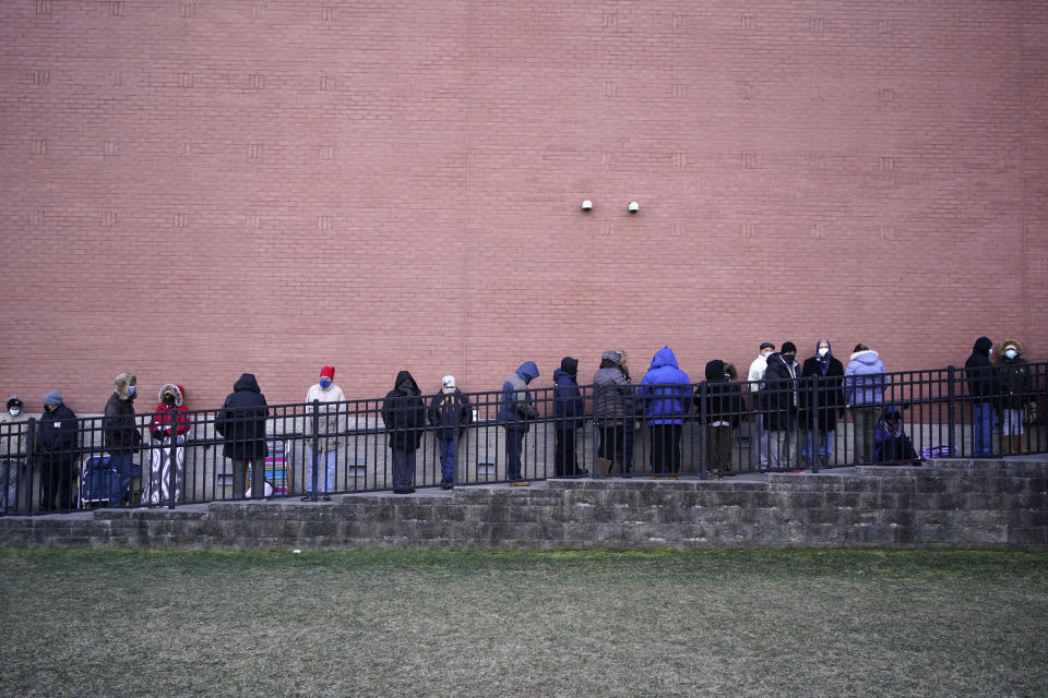 People wait in line for the COVID-19 vaccine in Paterson, N.J., Thursday, Jan. 21, 2021. The first people arrived around 2:30 a.m. for the chance to be vaccinated at one of the few sites that does not require an appointment. (AP Photo/Seth Wenig)