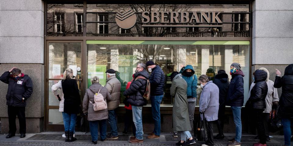 People queue outside a branch of Russian state-owned bank Sberbank to withdraw their savings and close their accounts following Russia's attack on Ukraine.