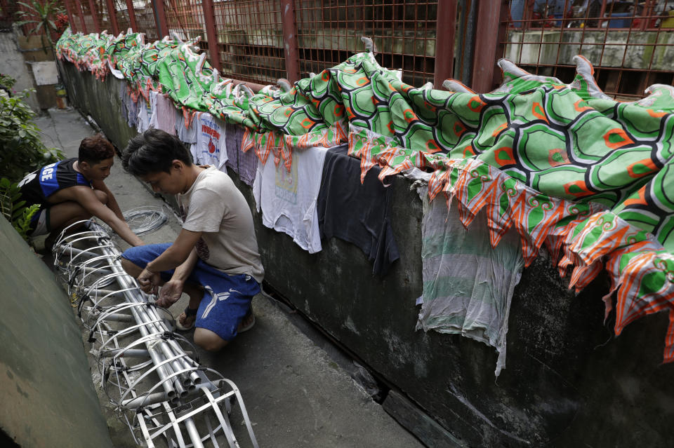 Carlo Sicat prepares the dragon's body as they seek other ways to earn a living at a creekside slum in Manila's Chinatown, Binondo, Philippines on Feb. 8, 2021. The Dragon and Lion dancers group won't be performing this year after the Manila city government banned the dragon dance, street parties, stage shows or any other similar activities during celebrations for Chinese New Year due to COVID-19 restrictions leaving several businesses without income as the country grapples to start vaccination this month. (AP Photo/Aaron Favila)