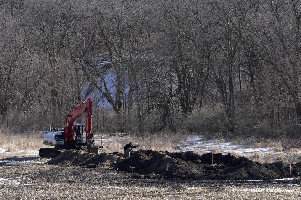 Workers install a bioreactor in a field, Friday, Feb. 10, 2023, near Nevada, Iowa. Simple systems called bioreactors and streamside buffers help filter nitrates from rainwater before it can reach streams and rivers. (AP Photo/Charlie Neibergall)