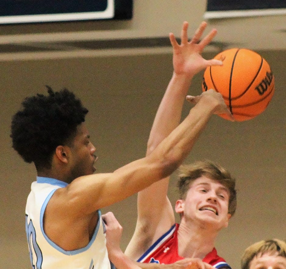 Bartlesville High guard David Castillo, left, makes a pass to the low post to teammate Kent Girard for a crucial fourth-quarter layup during Tuesday's home battle against Bixby High. Castillo scored the winning bucket in Bartlesville's 72-70 victory.