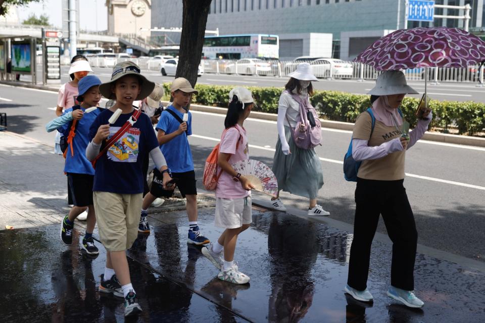 2023年7月5日，中國北京發布熱浪橙色警報，小朋友在路上吃冰消暑。路透社