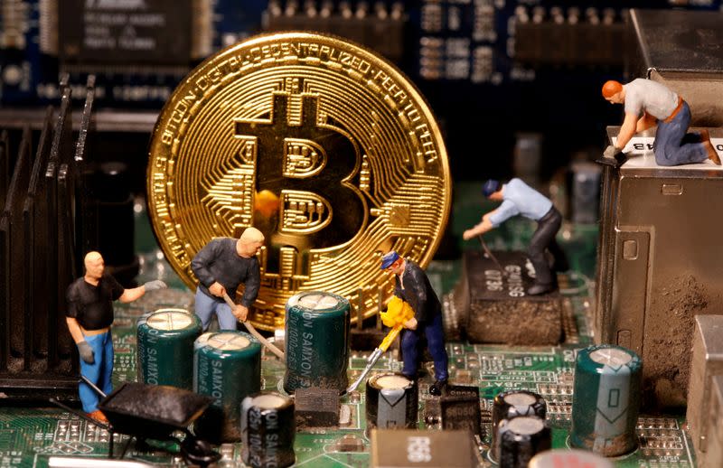 FILE PHOTO: A representation of virtual currency Bitcoin and small toy figures are placed on computer motherboard