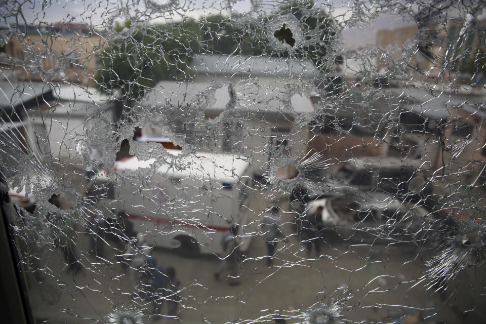 Afghan security security officers are seen through the shattered window of a maternity hospital after gunmen attacked, in Kabul, Afghanistan, Tuesday, May 12, 2020. Gunmen stormed the hospital in the western part of Kabul on Tuesday, setting off a shootout with the police and killing several people. (AP Photo/Rahmat Gul)