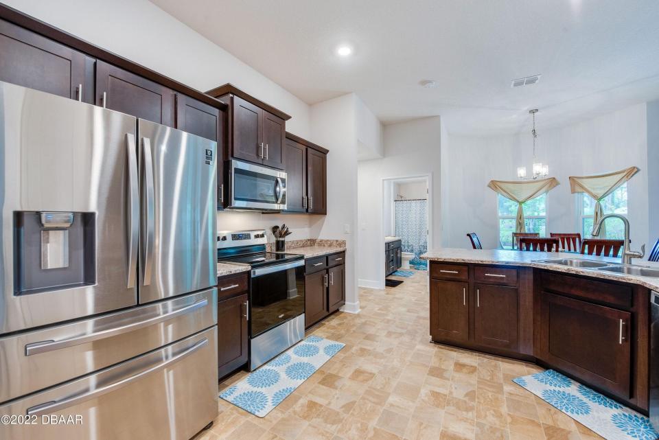 This beautiful open kitchen features stainless-steel appliances and separate pantry.