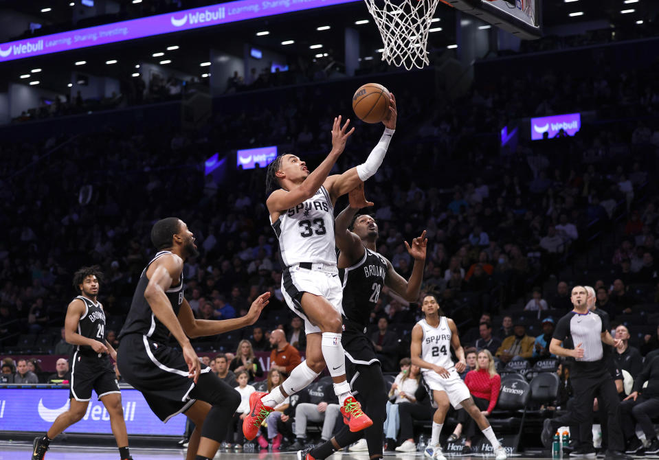 San Antonio Spurs guard Tre Jones (33) drives to the basket against Brooklyn Nets forward Dorian Finney-Smith (28) during the second half of an NBA basketball game, Saturday, Feb. 10, 2024, in New York. (AP Photo/Noah K. Murray)