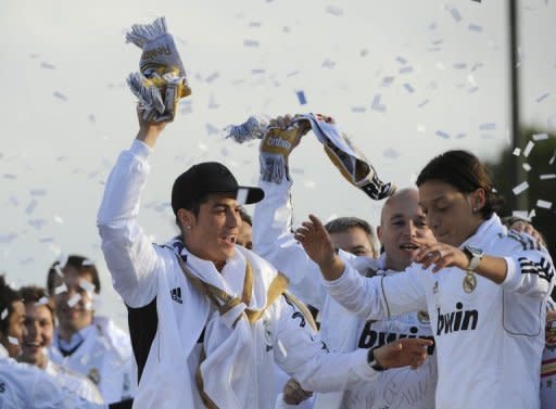 Real Madrid's Cristiano Ronaldo (L) and Mesut Ozil celebrate on an open bus at Cibeles square in Madrid, on May 3, a day after winning the Spanish league title for the first time since 2008. Real Madrid's 3-0 away win over Athletic Bilbao sealed the league, putting them seven points clear of last year's winners and arch rivals Barcelona with just two games to go