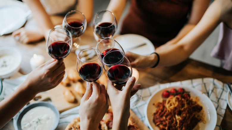 wine glasses clinking over dinner