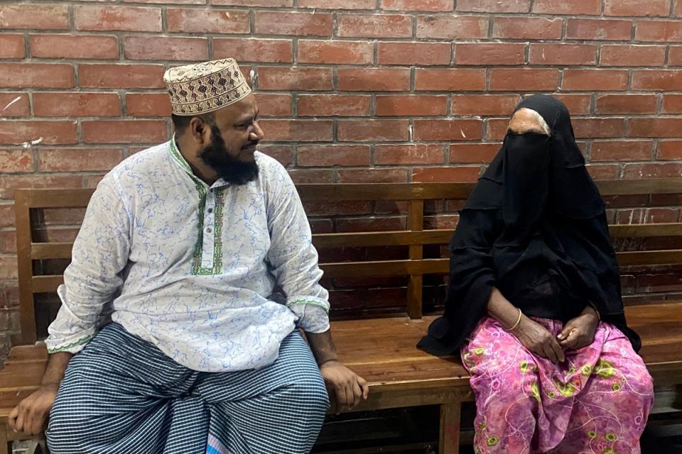 Landlord (L) and Sister of Bangladesh’s hangman Shahjahan Bouya sit at a hospital bench as they wait to receive Bhuiyan’s body (AFP via Getty Images)