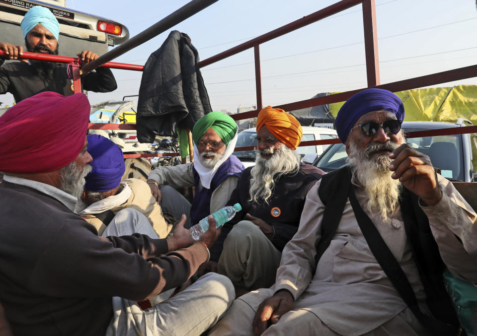 Elderly farmers arrive at one of the three main protest sites outside New Delhi's border with Uttar Pradesh in New Delhi, India, Friday, Feb. 5, 2021. India's agriculture minister on Friday defended the new agriculture reform laws in Parliament, dampening hopes of any quick settlement with tens of thousands of protesting farmers demanding their repeal by blocking three highways connecting New Delhi to northern India for over two months now. (AP Photo/Manish Swarup)