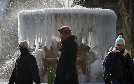 People walk past an ice covered Josephine Shaw Lowell Memorial Fountain, in frigid temperatures in Bryant Park in Manhattan, January 8, 2015. REUTERS/Mike Segar