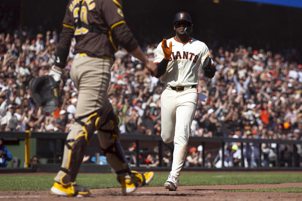 San Francisco Giants designated hitter Jorge Soler, right, applauds as he scores the go-ahead run against the San Diego Padres on a single by Matt Chapman during the eighth inning of a baseball game, Sunday, April 7, 2024, in San Francisco. (AP Photo/D. Ross Cameron)