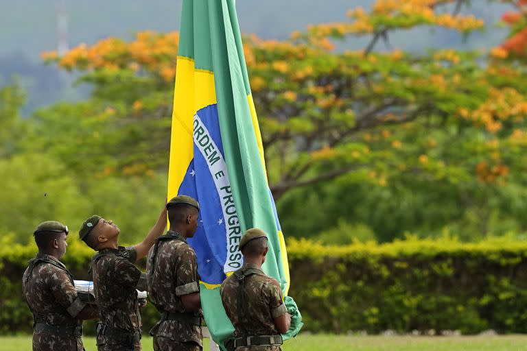 Soldados izan la bandera brasileña esta mañana en la residencia oficial del presidente en Brasilia