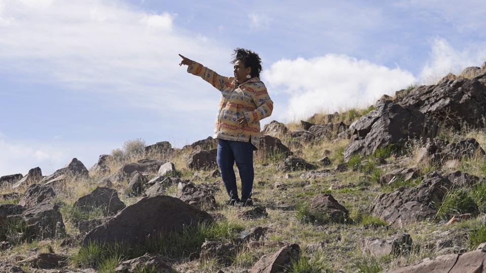 Michon Eben, historic preservation officer for the Reno-Sparks Indian Colony, looks on near a massacre site at Sentinel Rock on April 25, 2023, outside of Orovada, Nev. A huge lithium mine under construction in northern Nevada is at the center of a dispute over President Joe Biden's clean energy agenda. Eben said the agency's actions fell far short of genuine consultation. (AP Photo/Rick Bowmer)
