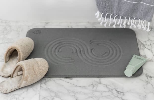 A luxe stone bath mat designed to absorb water and dry quickly