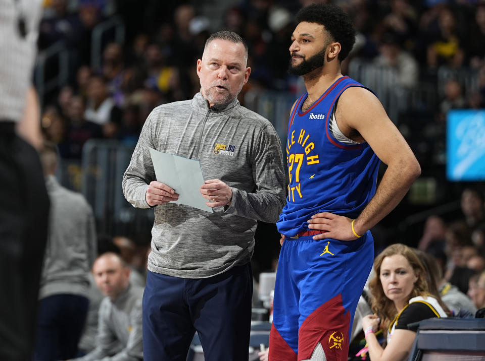 Denver Nuggets coach Michael Malone confers with guard Jamal Murray during the first half of the team's NBA basketball game against the Phoenix Suns on Tuesday, March 5, 2024, in Denver. (AP Photo/David Zalubowski)