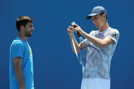 Czech Republic's Tomas Berdych adjusts his raquet's tape as his coach Dani Vallverdu looks on during a practice session at Melbourne Park, Australia, January 17, 2016. REUTERS/Jason O'Brien