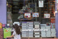 A young girl wearing a face mask walks past a store displaying a coronavirus information poster and selling children's school stationery, backpacks, protective masks and hand sanitizers in Madrid, Spain, Monday, Aug. 24, 2020. Despite a spike in coronavirus infections, authorities in Europe are determined to send children back to school. Schools in the Spanish capital are scheduled to open on Sept. 4. (AP Photo/Paul White)