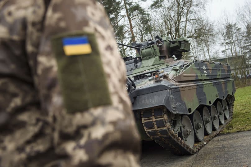 A Ukrainian soldier is standing in front of a Marder infantry fighting vehicle at the German forces Bundeswehr training area in Munster, 20 February 2023